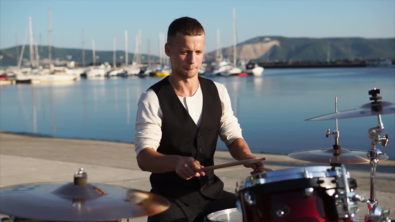 Drummer playing drums by the sea