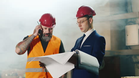 dos ingenieros estudian dibujos trabajan en el almacén 3