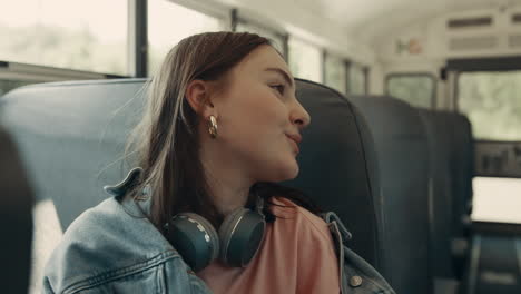 schoolgirl sitting school bus close up. teenager girl talking with classmates.