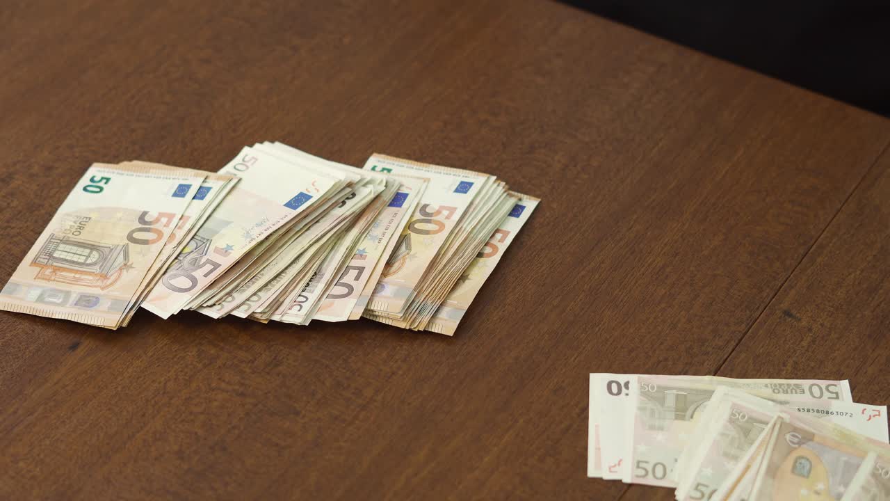 Nærbilde av hender som kaster eurosedler på bordet og plukker dem opp igjen. Konsept for finansiell anger, stress og beslutningstaking