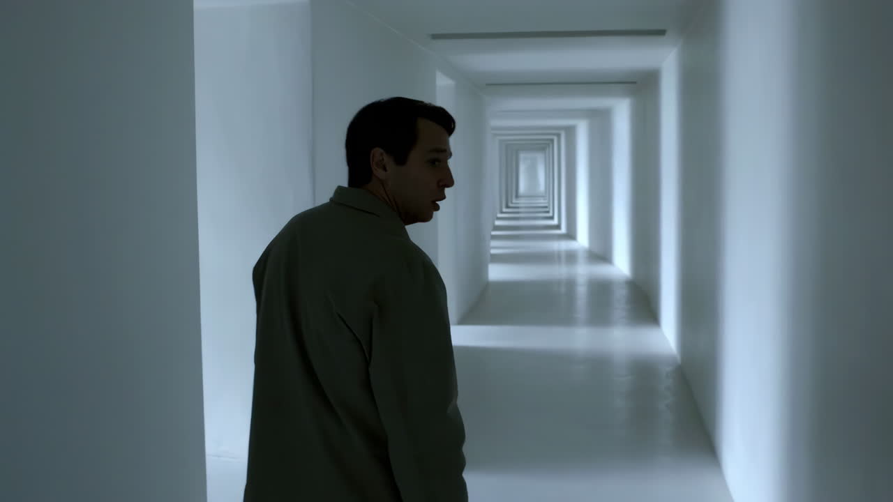 Man in an infinite white hallway