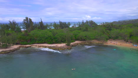 Left-to-right-aerial-view-of-Hale'iwa-Beach-and-surfers-on-the-coast-oof-Oahu-Hawaii