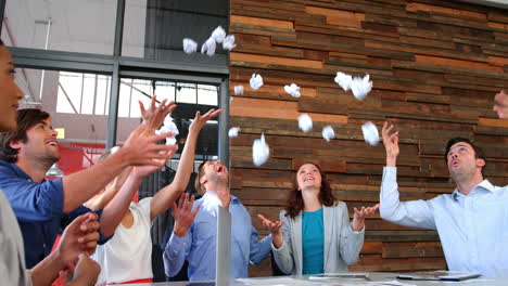 business executives throwing crumpled paper in air