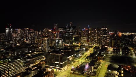 Downtown-Seattle,-Washington-glows-in-the-night---pullback-aerial-reveal