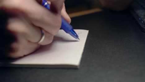 Extreme-closeup-shot-of-male-hand-taking-notes-on-paper