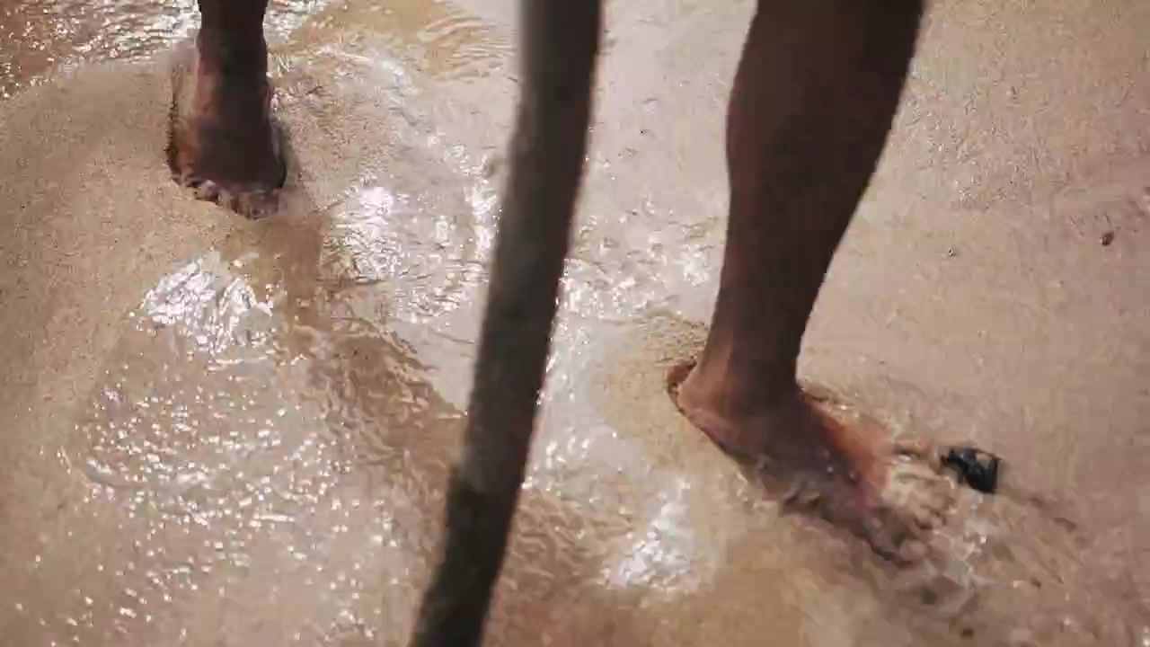 Ripresa con gimbal di piedi che camminano sulla spiaggia in una giornata di sole. Bagamanoc, Filippine.