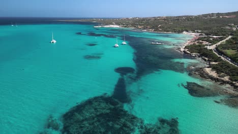 la playa de la pelosa con catamarán en la clara laguna azul, cerdeña