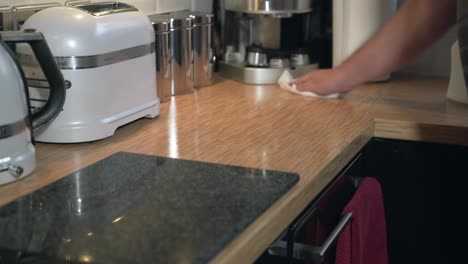 Spraying-cleaner-on-kitchen-counter-top-and-whiffing-clean-with-paper-towel