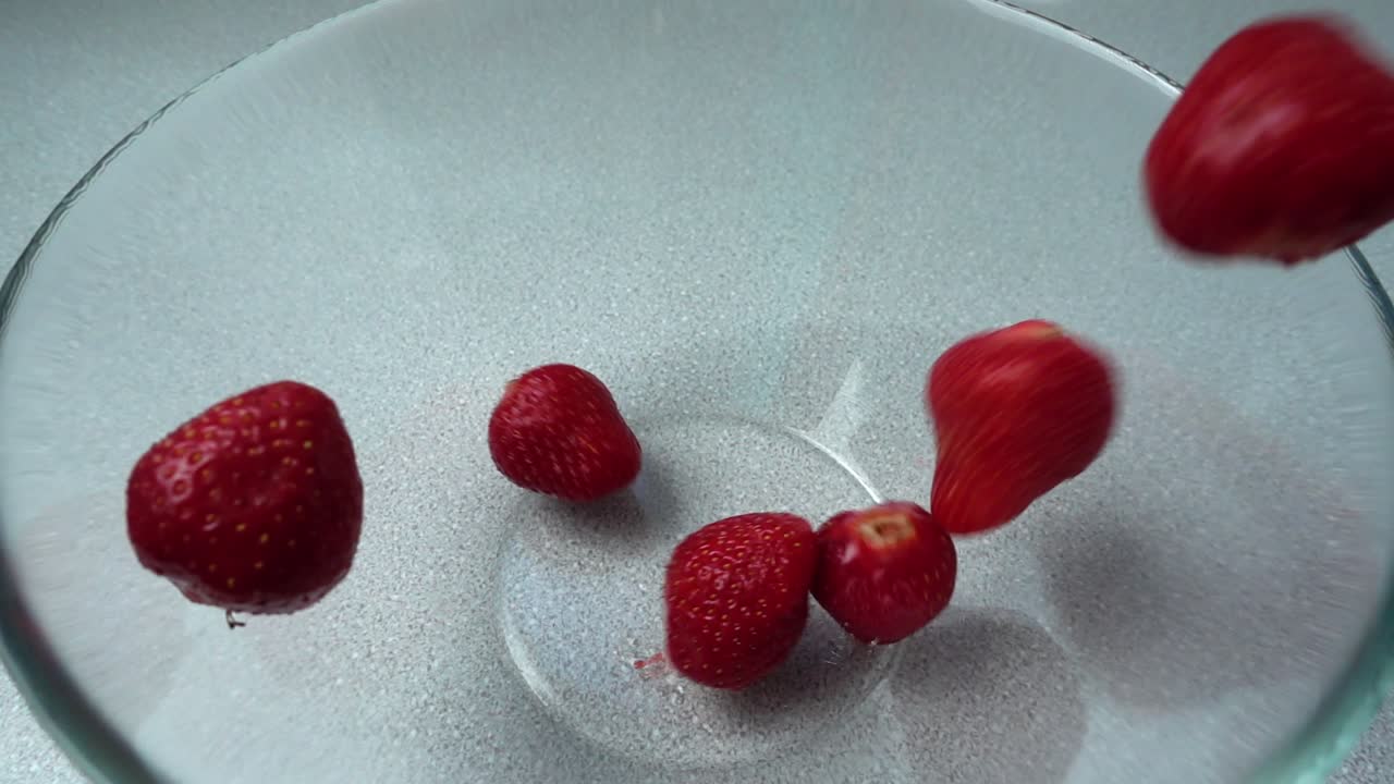 Falling of strawberry in a glass bowl. Slow motion