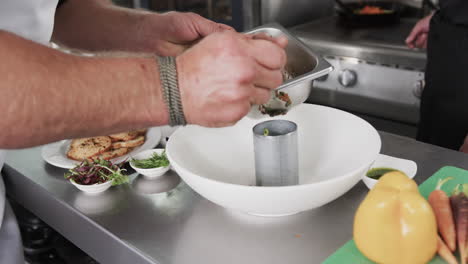 Caucasian-male-chef-putting-meal-into-mold-on-counter-in-kitchen,-slow-motion