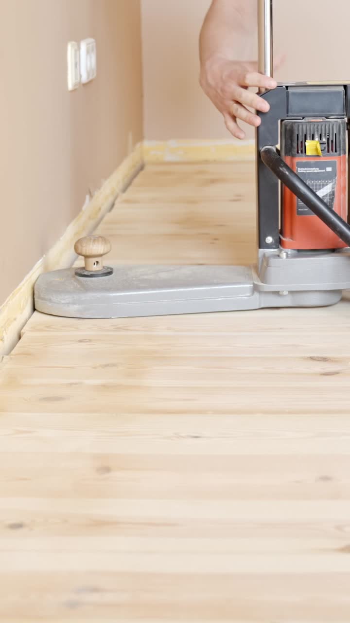 Professional contractor sanding the edges of a parquet floor before sealing