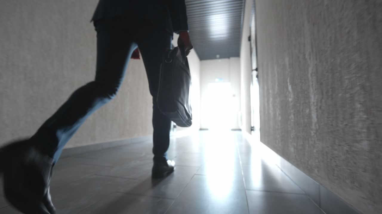 Businessman Walking Down a Hallway