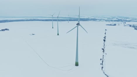 Vista-Aérea-En-Un-Parque-De-Molinos-De-Viento,-Las-Palas-Giran-Y-Producen-Electricidad-Para-Los-Consumidores