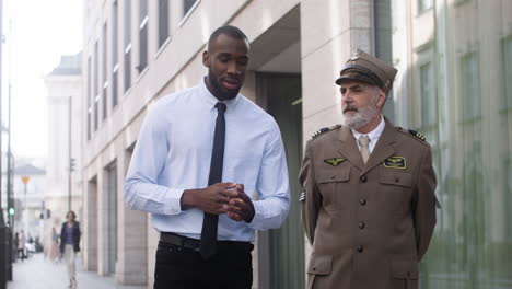 two men walking and talking on the street