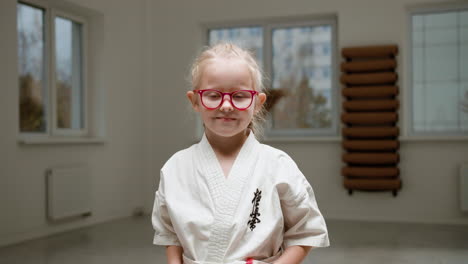 chica en kimono blanco en la clase de artes marciales