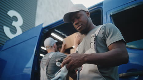 delivery workers handling packages from a blue van