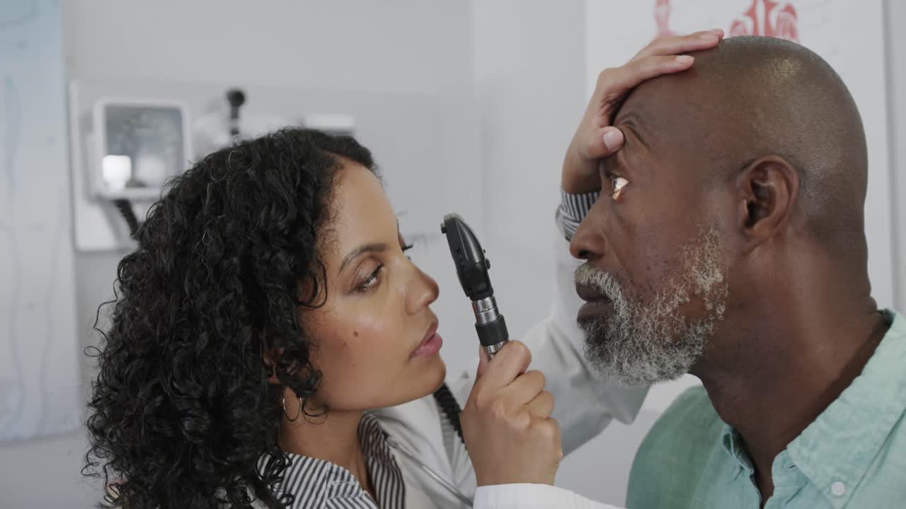 diversa doctora examinando los ojos de un paciente masculino en la sala de consulta, cámara lenta