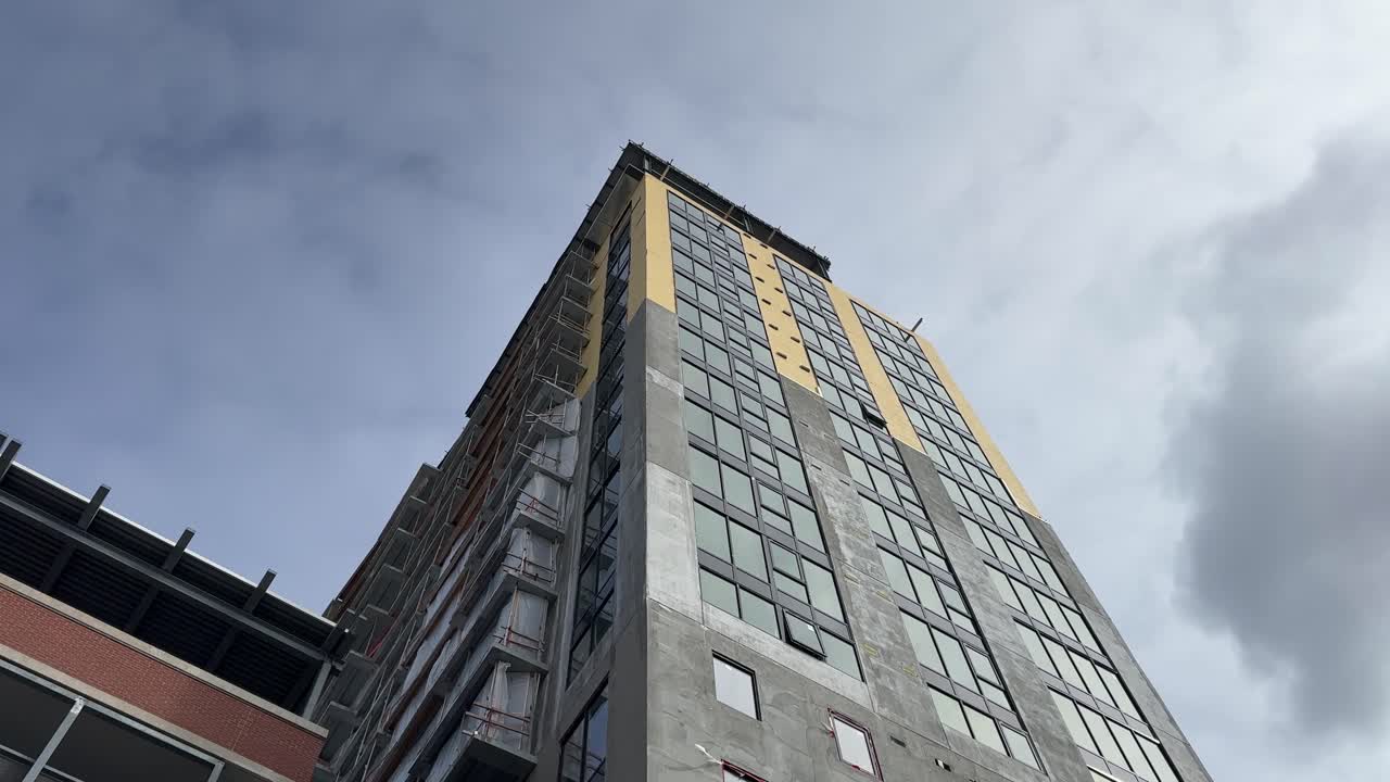 ángulo bajo mirando hacia arriba en el edificio en construcción con cielo azul y nubes