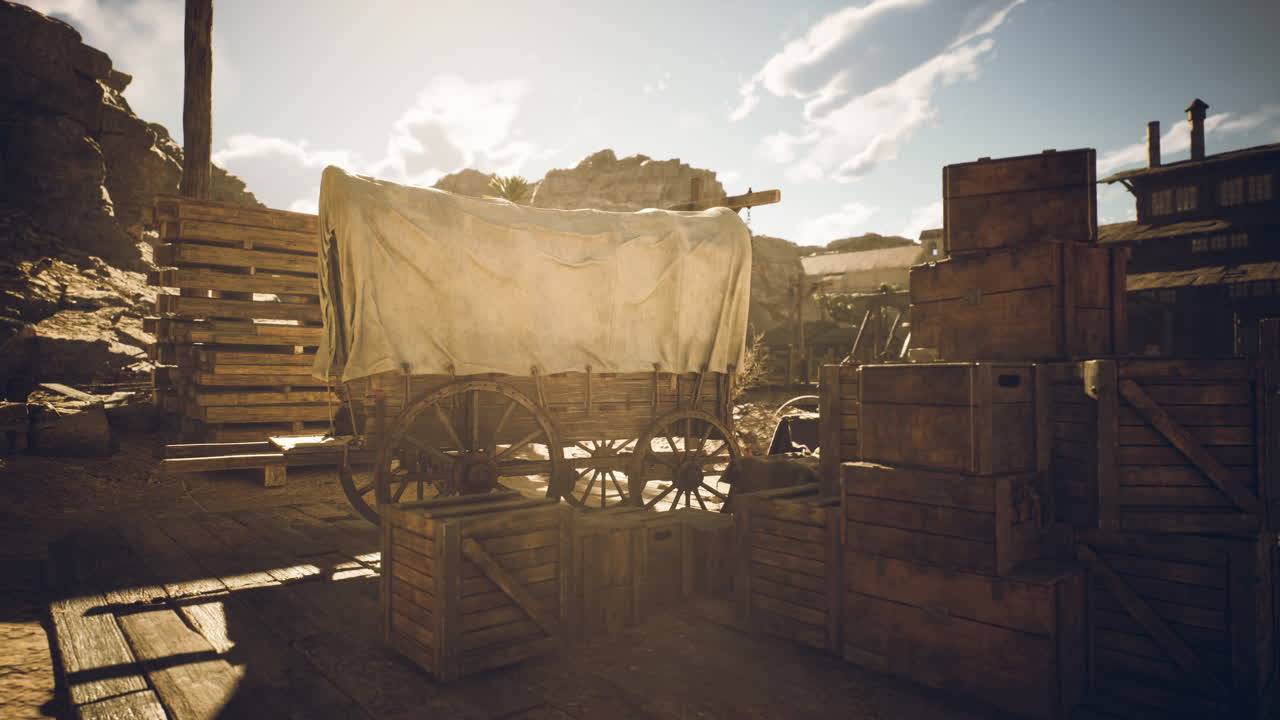 Historic covered wagon in a dusty settlement during late afternoon