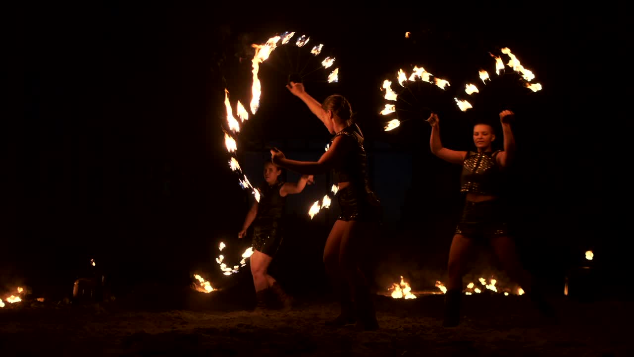 cámara lenta: actuación de fuego profesional tres mujeres con antorchas y un hombre con lanzallamas