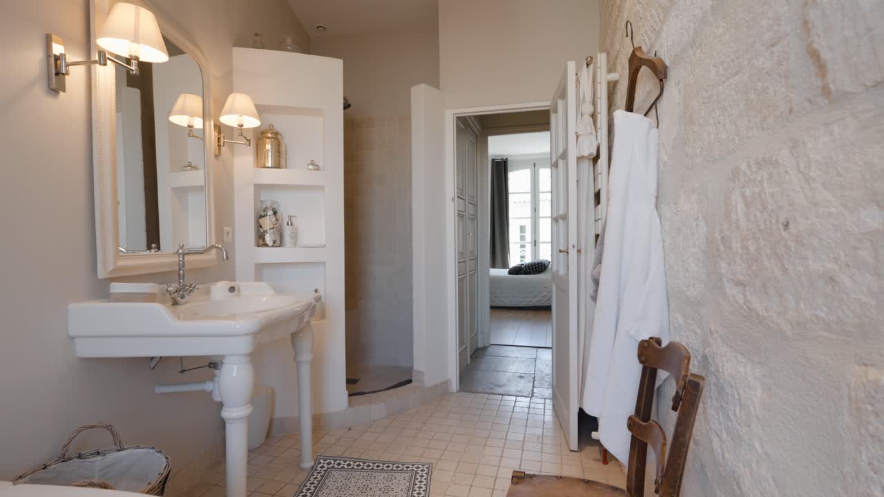 Slow establishing shot of an open stone shower with an standalone bathtub