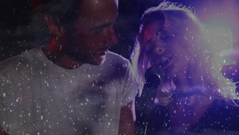 male performer and female vocalist singing music duet on stage, showing floating confetti effect