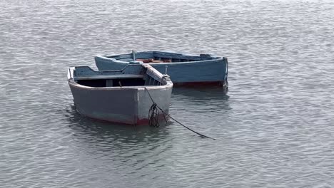 Barcos-Anclados-Flotando-Suavemente-En-El-Océano-Mientras-Baja-La-Marea-Temprano-En-La-Mañana.