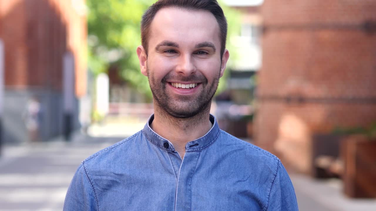 pulgares hacia arriba por hombre casual en el trabajo, mirando a la cámara