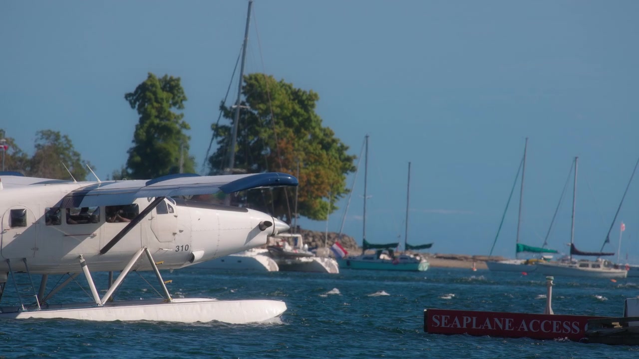 Idrovolante che parte dal molo del porto di una piccola isola.