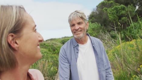 Sonriente-Pareja-Caucásica-Senior-Cogidos-De-La-Mano-Y-Caminando-Por-El-Sendero-Al-Aire-Libre