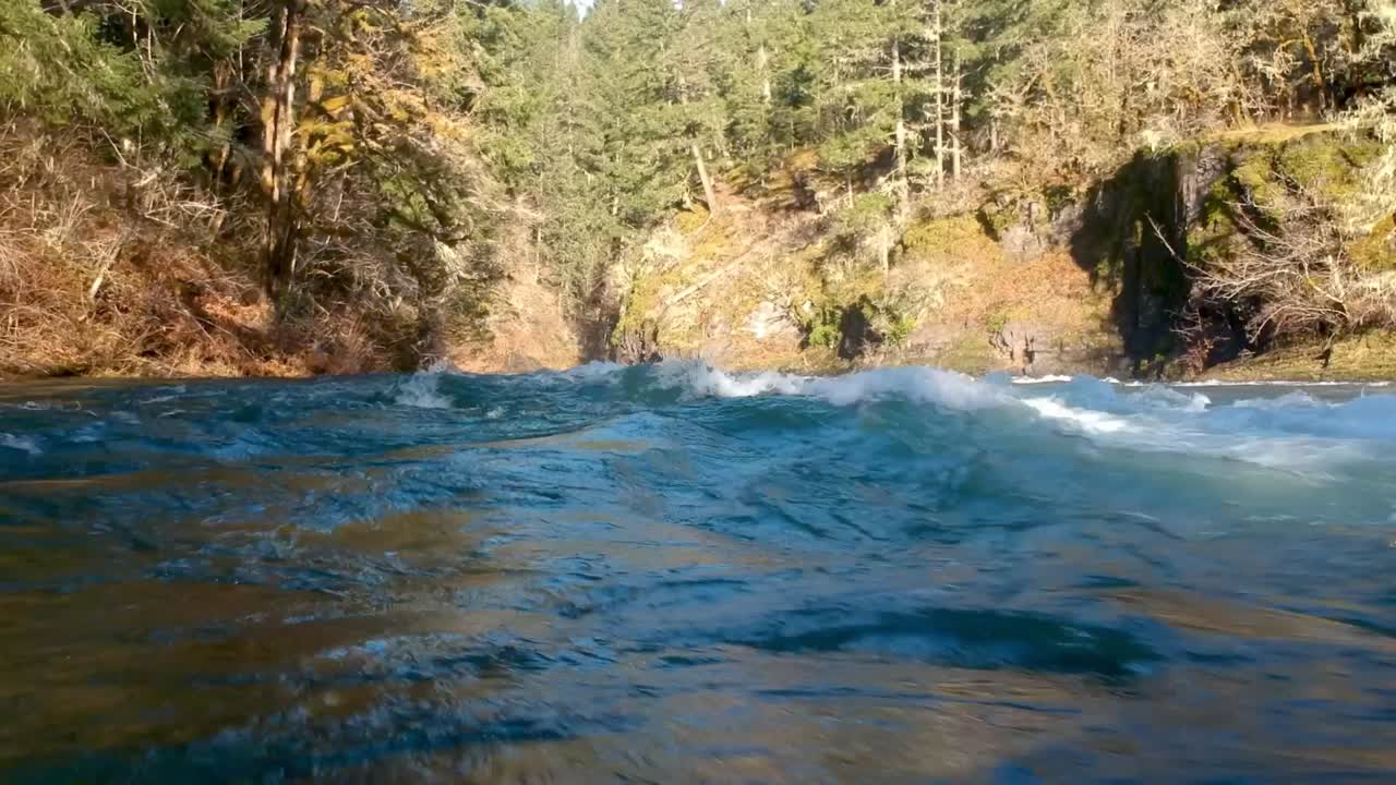 Low angle shot close to wild river water rapids with canyon in background