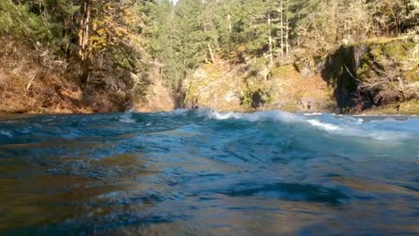 low angle shot close to wild river water rapids with canyon in background