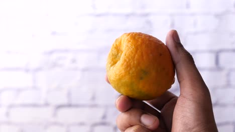 una sola naranja en la mano