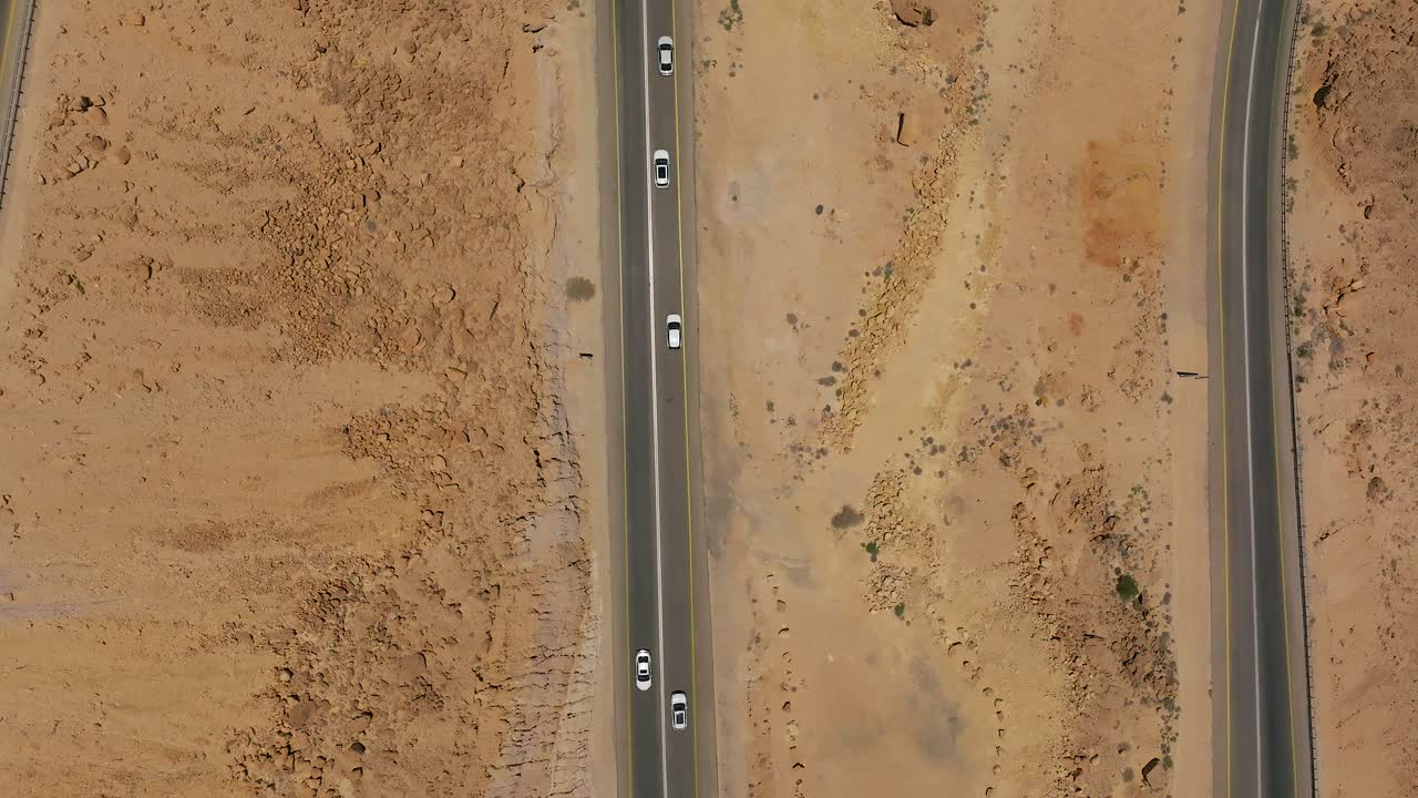 사막의 산길을 따라 올라가고 내려가는 낮의 교통의 공중 전망