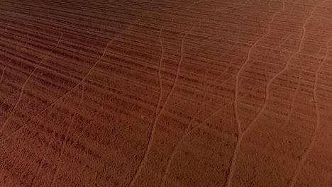 aerial reverse dolly revealing a working windpump on a farm with plowed unused land