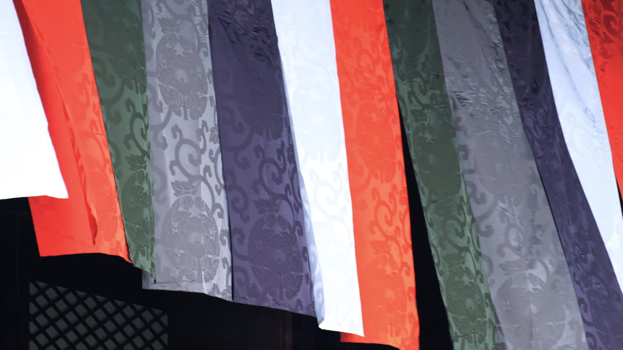 Vibrant decorative textile banners with traditional motifs used in Shinto or Buddhist festivals