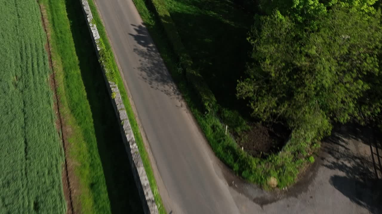 Caledon Border Wall, County Tyrone, Northern Ireland, May 2023. Drone pushes forward then ascends to birdseye, historic divide wall, rural farmland, lush greenery and scenic Irish countryside.