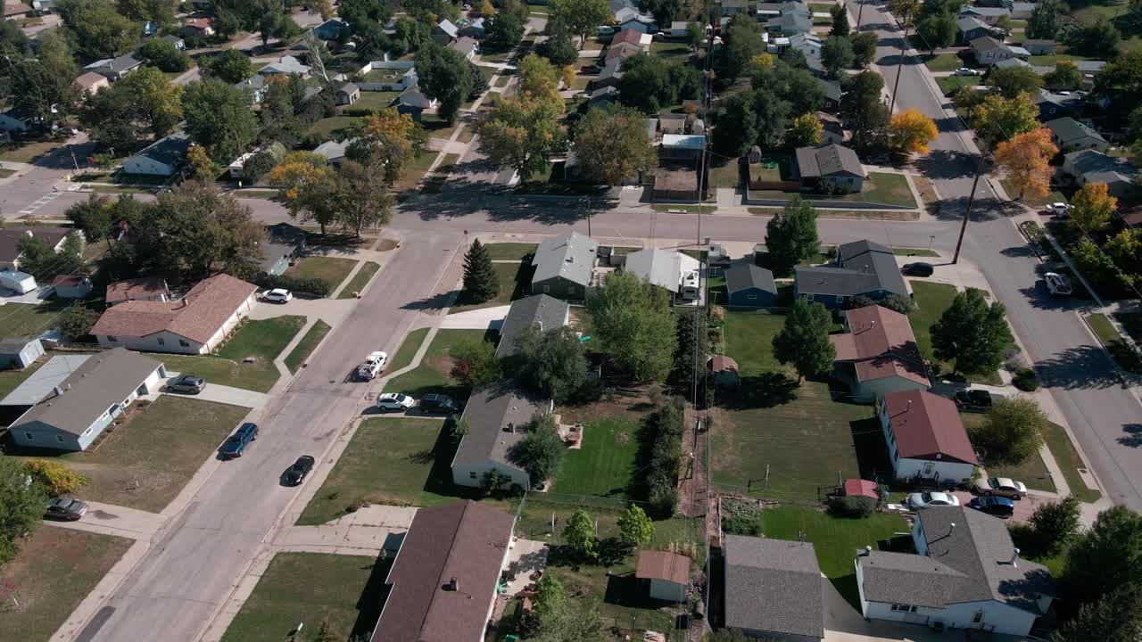 A wide drone shot moving left to right, and panning up and down showing houses in a neighborhood
