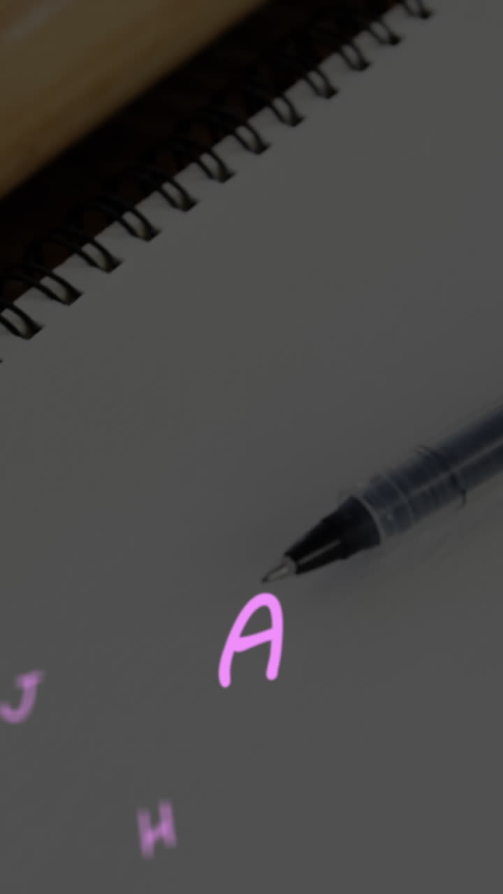 Animation of letters over notebook and pen