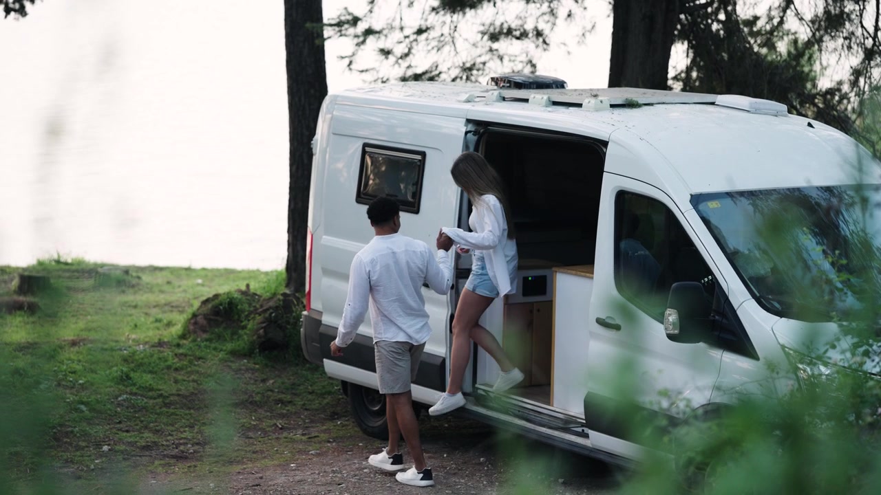 Young Couple Exits Camper Van to Enjoy Nature by Lake