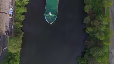 Luftdrohne-Von-Oben-Nach-Unten-über-Wasser-Geschossen,-Ein-Schiff-Passiert-Grüne-Landschaft-Und-Umwelt