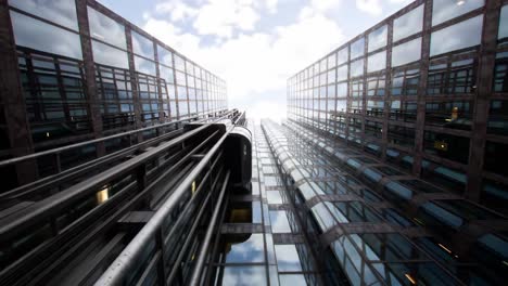a stunning view of modern skyscrapers captured from ground level, featuring reflections of glass facades and a bright sky in the background