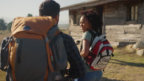 rear view of group of friends with backpacks hiking in countryside together