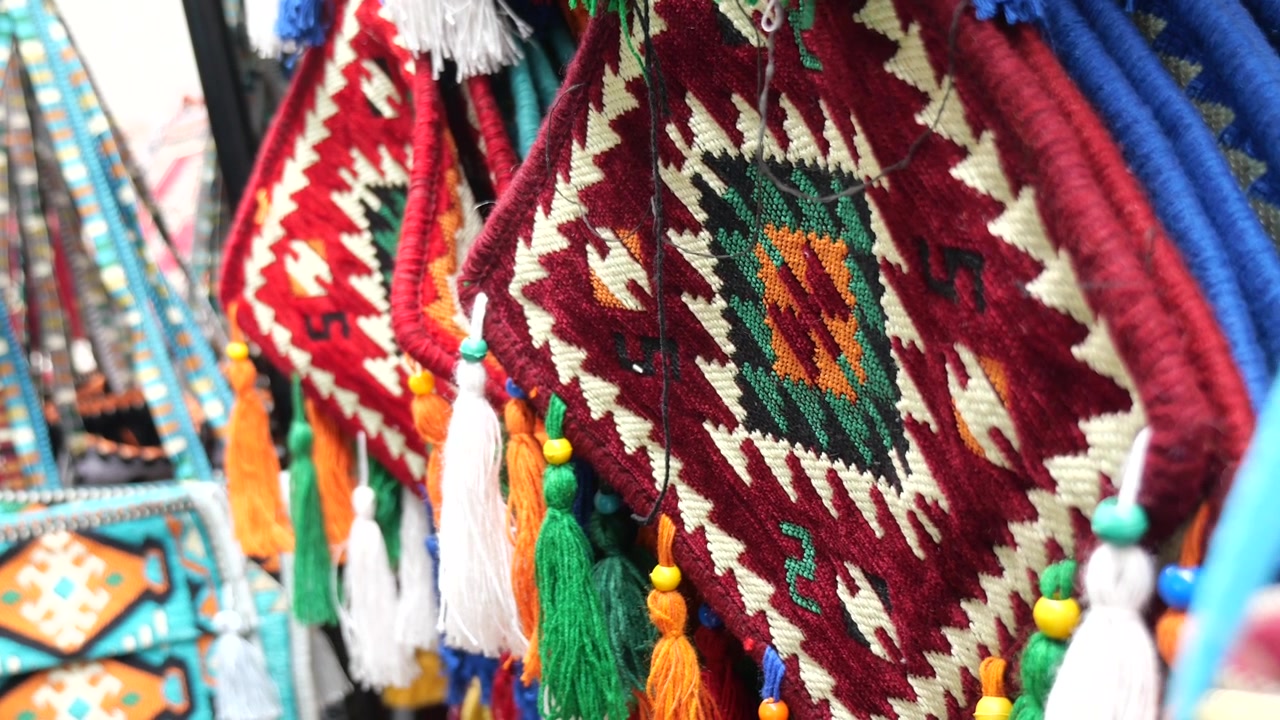 Borse intrecciate tradizionali fatte a mano con nappe colorate al mercato