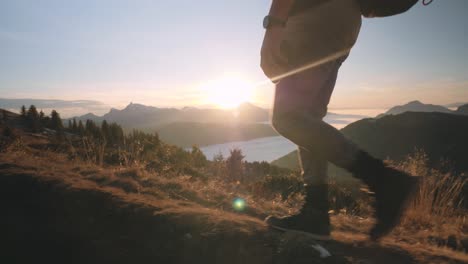 young man walking in the mountain with parachute bag and helmet at dusk in chamonix, france. - close up