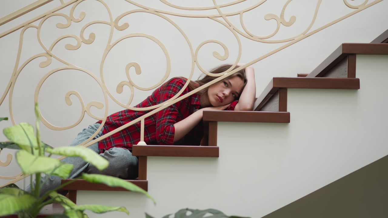 una mujer traumatizada yace en la escalera. una mujer apática pierde la razón para vivir después de sobrevivir a un accidente automovilístico en casa. una mujer pensativa trata con la depresión