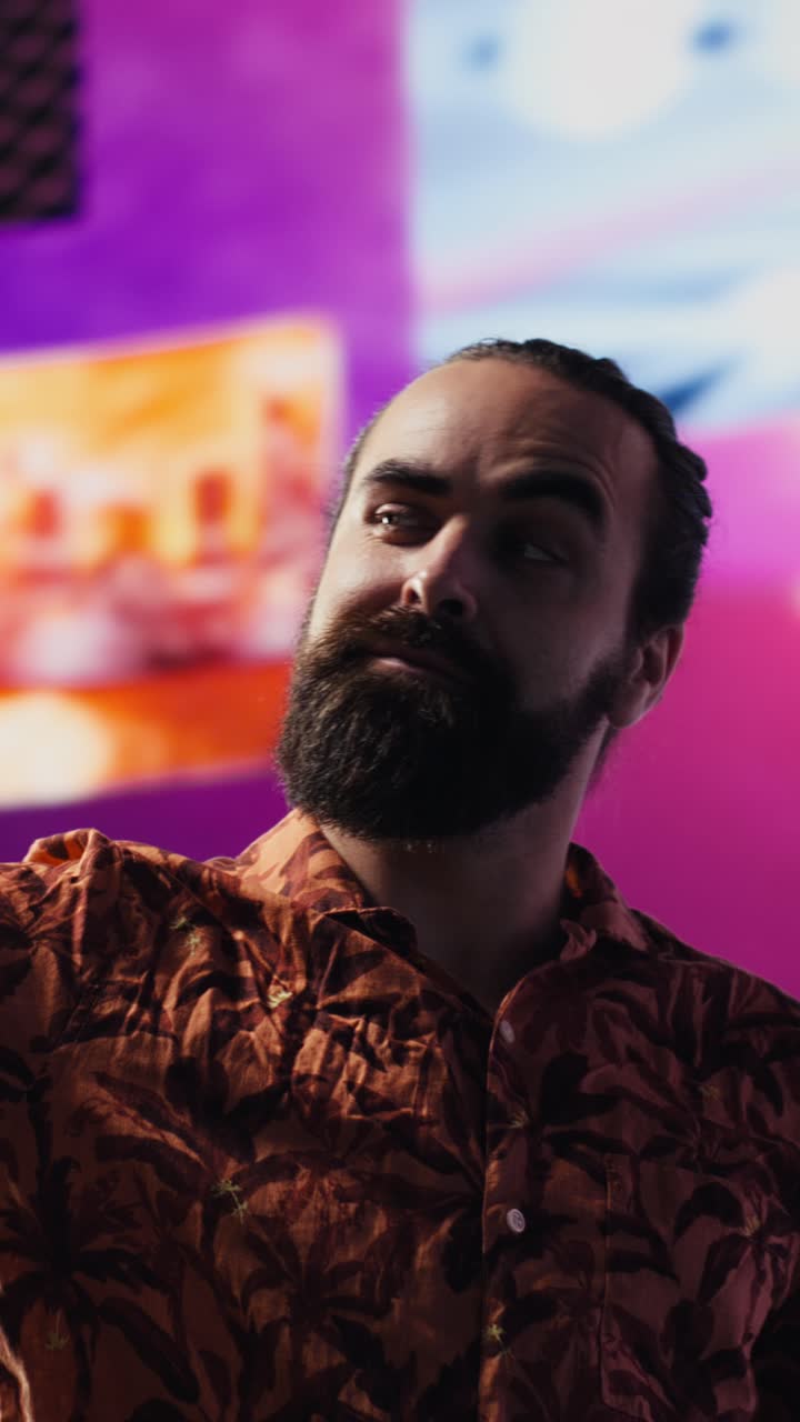 Vertical Video Young carefree man takes selfies and videos surrounded by fun neon lights