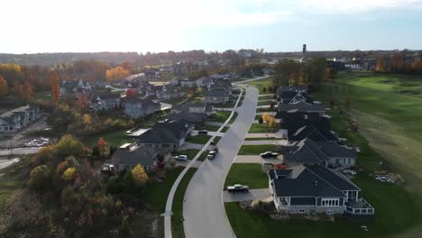 Aerial-view-flying-through-an-Ontario-neighborhood-next-to-a-golf-course-at-sunset