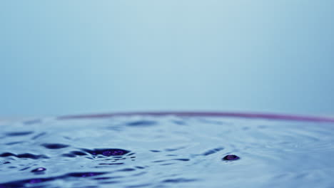 ice cube swirling and splashing through colorful water