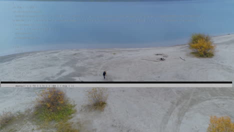 Person walking on vast sandy landscape with code overlay animation